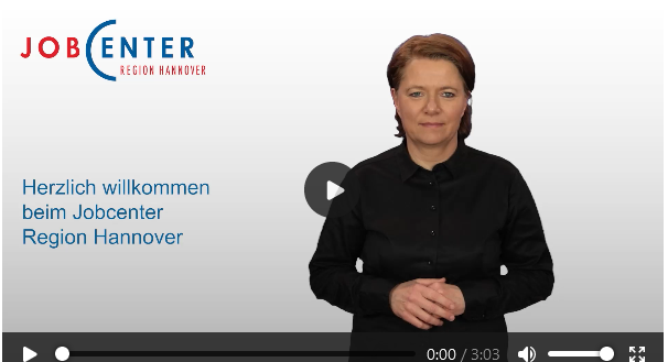 Beispiel eines Gebärdensprachvideos auf der Website des Jobcenter Region Hannover.
Eine Frau steht mit gefalteten Händen vor einem Hintergrund mit dem Logo des Jocenter Hannover. Auf dem Bild steht der Text 'Herzlich Wilkommen beim Jobcenter Hannover'